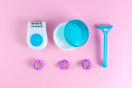 s shaving razor and flowers on a pink background. Depilatory. Re