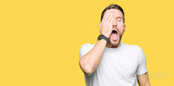 男人穿着休闲的白色t恤打哈欠累得用手捂住半张脸眼睛和嘴巴脸疼死了