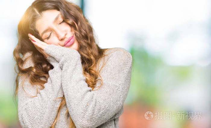 年轻漂亮的女人穿着冬天的连衣裙睡得很累做梦双手合在一起摆姿势闭着