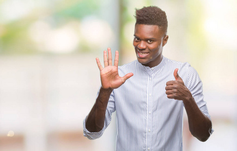 年轻的非裔美国男人在孤立的背景下，用手指第六，同时微笑，自信和快乐。