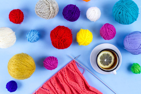 编织。 蓝色背景下用柠檬编织茶叶的针织针。 舒适的周末是最喜欢的消遣。 爱好