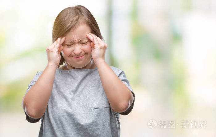 年轻的成年妇女患有唐氏综合症在孤立的背景下手在头上疼痛因为压力偏
