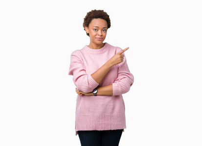 美丽的年轻非洲裔美国妇女在孤立的背景下，用手指着一边，显示出广告严肃而平静的脸