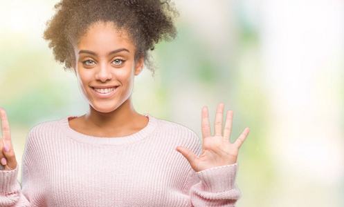 年轻的非洲美国女人穿着冬天的毛衣，在孤立的背景上，用手指第六，同时微笑着自信和快乐。