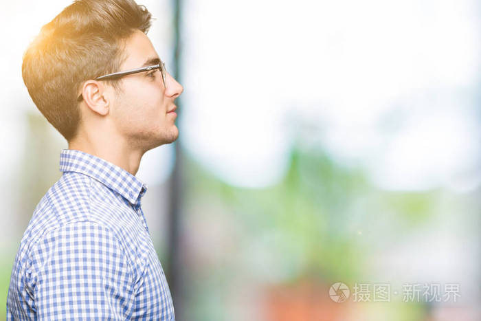 年轻英俊的男人戴着眼镜在孤立的背景下看着侧面放松的轮廓自然的脸