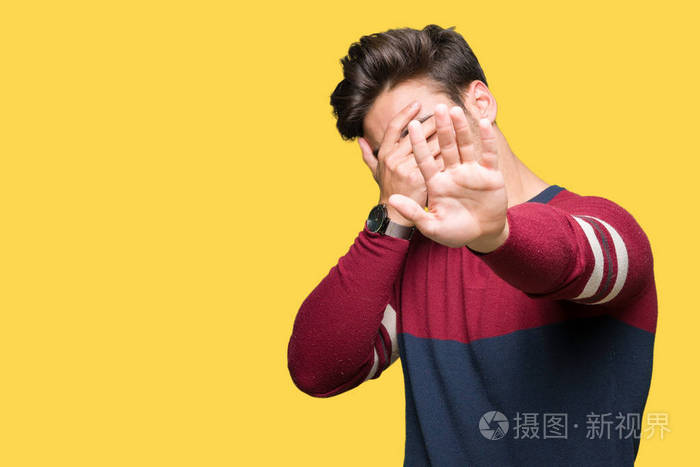 年轻的帅哥在孤立的背景上用手遮住眼睛,用悲伤和恐惧的表情做停止的