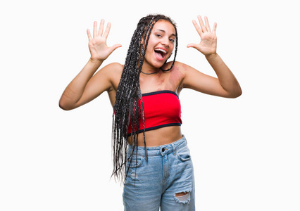 年轻的辫子非裔美国人，有色素沉着缺陷的出生标记，在孤立的背景上，显示和指向十号手指，同时微笑自信和快乐。