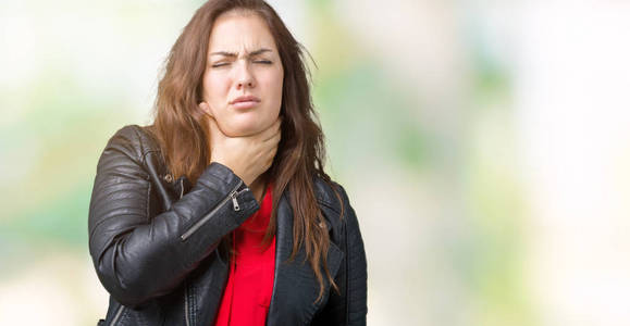 一位年轻女士穿着时尚皮夹克，穿着一件独立的背景，摸着疼痛的脖子，喉咙痛，感染了流感病毒