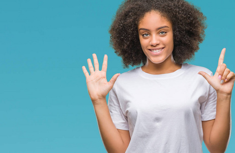 年轻的非洲美国妇女在孤立的背景显示和指向7号手指，同时微笑自信和快乐。
