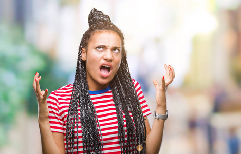 坏了发髻年轻的辫子非洲裔美国女孩在孤立的背景下疯狂和疯狂的喊叫和