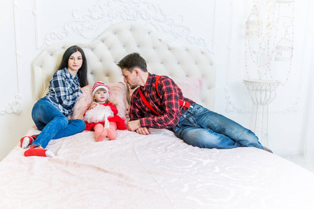 s father and little girl dressed in holiday wear red hats, jeans