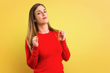 自我满足年轻的金发女人骄傲,自我满足,爱自己的概念,黄色背景照片