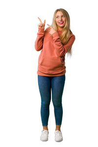 一个年轻女孩用食指指着，抬头看着孤立的白色背景的完整镜头