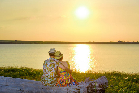 日落在水的背景上. 明亮多汁的绿草和温暖的夕阳.
