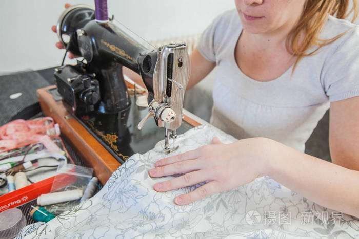 女裁缝用复古缝纫机在家做衣服.