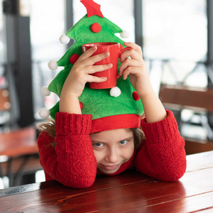 圣诞节坐在咖啡馆里的小女孩