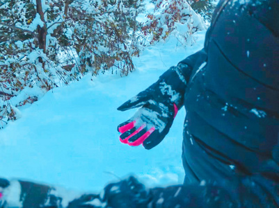 孩子拿着雪球。 积雪覆盖树木和云杉冬季在山上。 近距离射击。