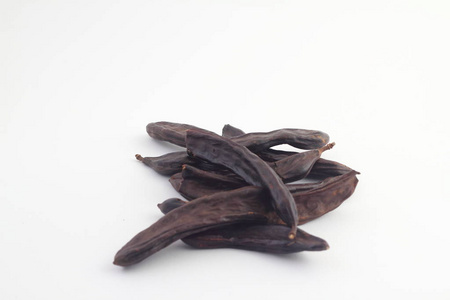 白色背景上的Carob。有机豆荚与种子