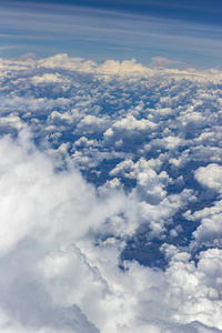 从空中飞过云层的窗户看到美丽的景色。带云的自然全景..白云在地上移动。