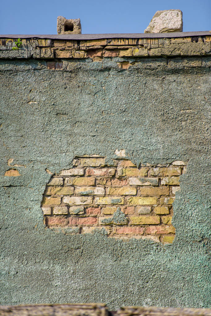 红砖和灰色粉刷石膏.古老的老式墙.照片背景.水泥中的裂缝.