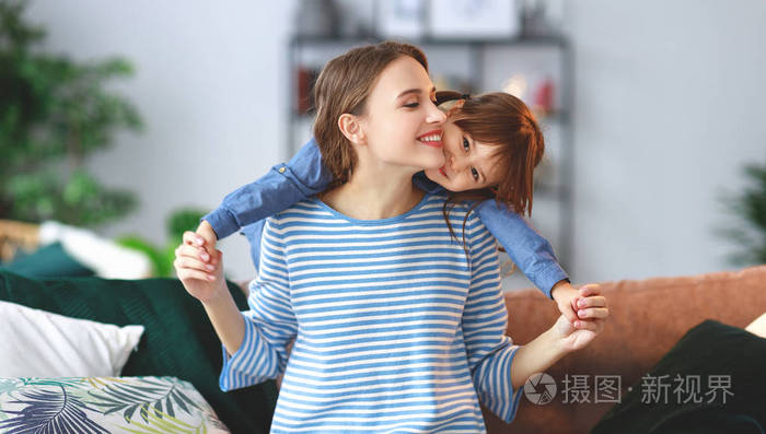 幸福的爱的家庭一个母子的女儿拥抱在家里
