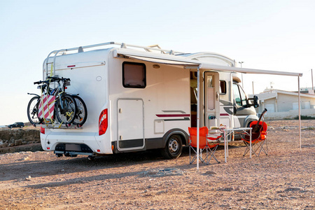 在娱乐车辆露营拖车附近的天篷下有空折叠椅和桌子。 冒险旅程积极的人旅行汽车之家概念