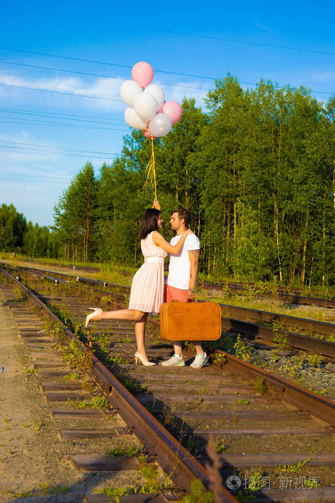 在阳光明媚的日子里有的情侣走在火车栏杆上