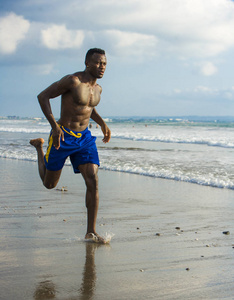 年轻有魅力的运动员和强壮的黑人非裔美国人在海滩上跑步，在职业运动员的生活方式中努力训练，在海水上冲刺，并撕裂跑步锻炼