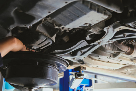 车辆提升通过液压进行电机换油和传动检查。 更换汽车修理服务中的机油。 汽车车间的维修和检查。