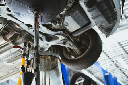 车辆提升通过液压进行电机换油和传动检查。 更换汽车修理服务中的机油。 汽车车间的维修和检查。