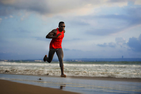 年轻，有吸引力，适合运动，强壮的黑人，美国男人在海滩上跑步，努力训练，在海水上冲刺，在职业运动员的生活方式和撕裂跑步锻炼