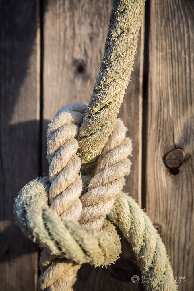 安全和连接概念.机动船,用结实的海绳系在码头上的小船