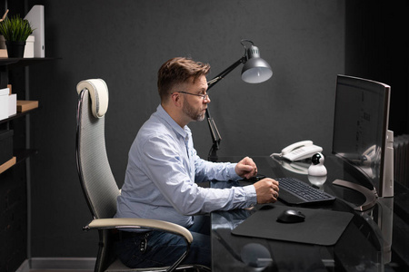 坐在办公室里的商务人员坐在电脑桌前看显示器照片