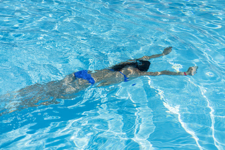 游泳动作女子在游泳池里跳水.年轻美丽的女孩在游泳池里游泳.