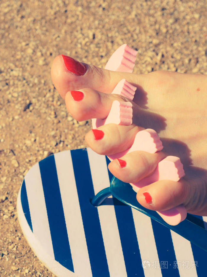 在暑假期间等待直到她的脚指甲在阳光下干燥的女人有脚趾分开的雌性