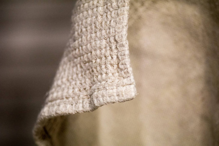 亚麻材料是弯曲的。 毛巾亚麻布悬挂和自然曲线。 织物的灰色天然颜色