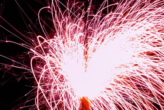 黑色背景上美丽的火花火焰. 烟火的模糊灯光.