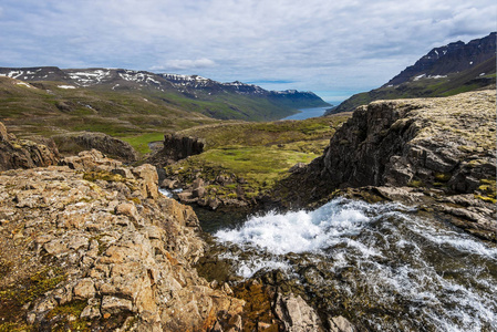 位于冰岛东部的Fjardabyggd市Mjifjordur山谷和Fjord的水流景观处于背景状态