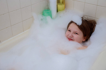 快乐的婴儿在洗澡时在泡沫中游泳。 婴儿淋浴。