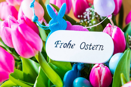 木制木板上的复活节鸡蛋和郁金香，德国文字快乐复活节