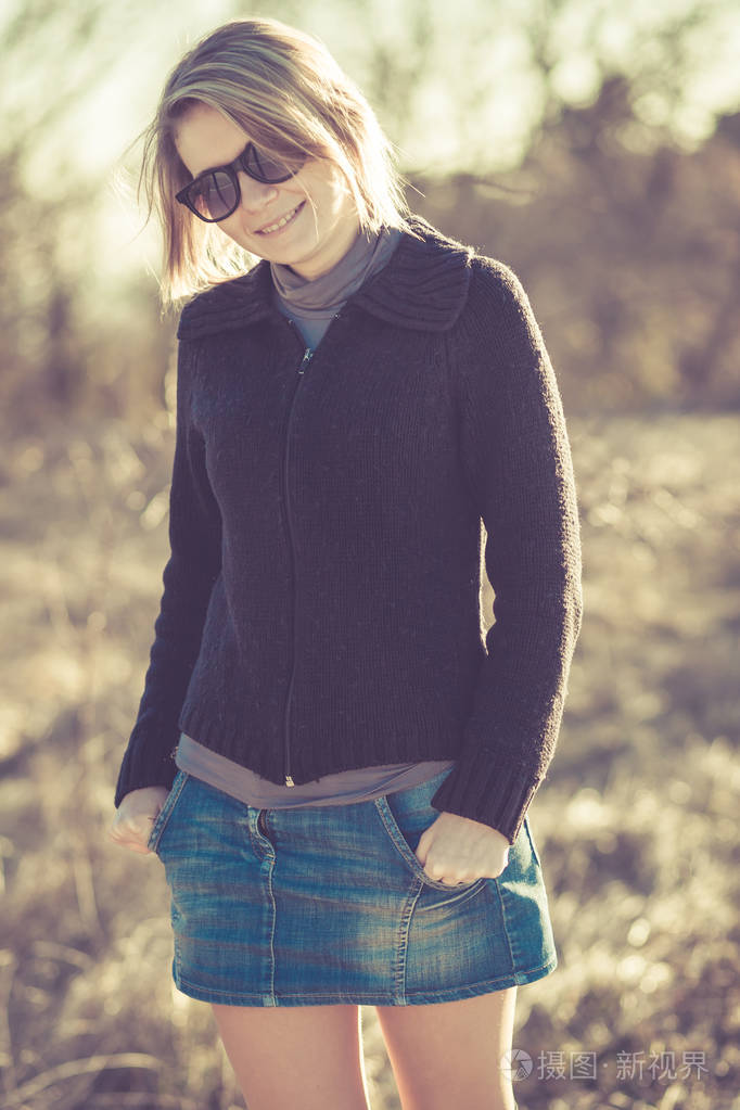 年轻时尚的金发美女在田野景观上摆姿势.观念爱与情感.彩色图像.