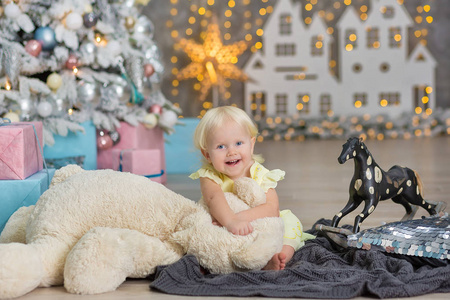 圣诞快乐假期快乐可爱的小女孩正在室内装饰圣诞树