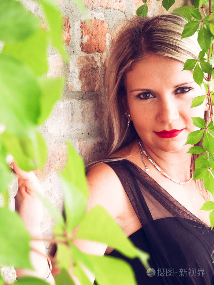 意大利威尼斯阳光明媚的街道上穿着黑色连衣裙的妇女的形象