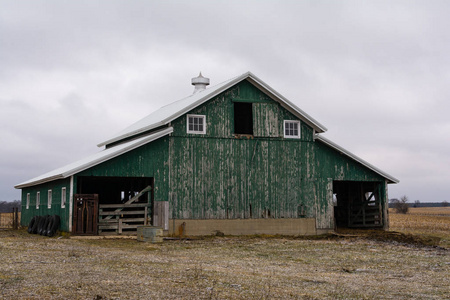 一场雪尘后的老式绿色谷仓. 伊利诺伊州米尔布罗美国照片