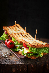 自制三明治与火腿, 生菜, 奶酪和西红柿在木制背景