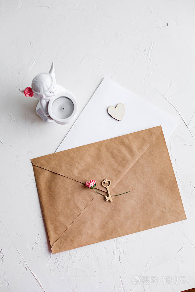 给心爱的人的信的顶部视图牛皮纸信封木制的小心和白色桌子上的一张纸