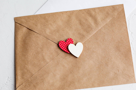 给心爱的人的信的顶部视图。 牛皮纸信封木制的小心和白色桌子上的一张纸。