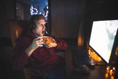 小可乐情绪化的年轻人晚上在电脑前吃薯片和可乐.