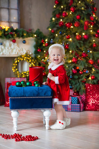圣诞快乐，节日快乐可爱的小女孩正在室内装饰圣诞树