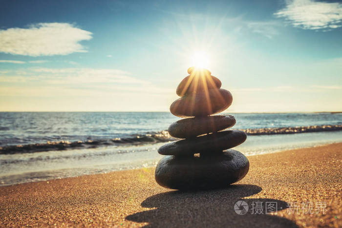 石头在沙滩上保持平衡日出拍摄禅定瑜伽练习